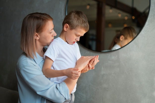 自宅で自閉症の息子の世話をする母親