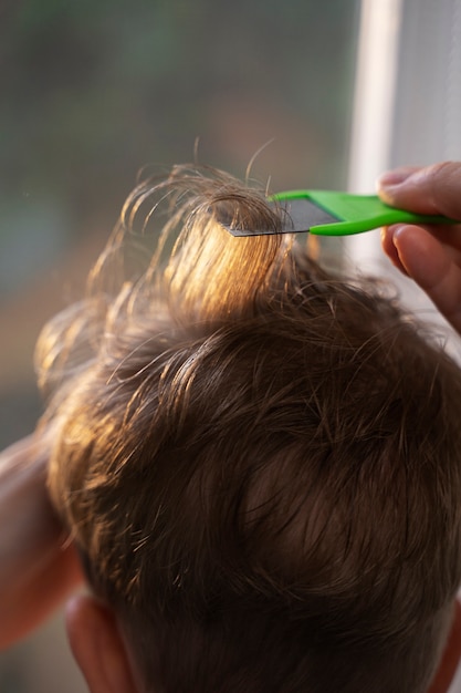 Madre che si prende cura di suo figlio con i pidocchi