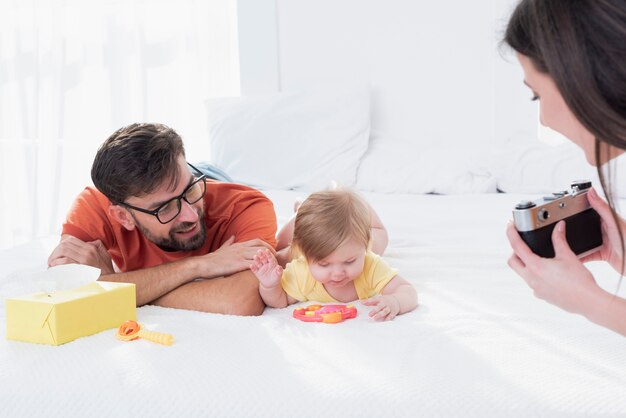 Mother taking picture of baby and father