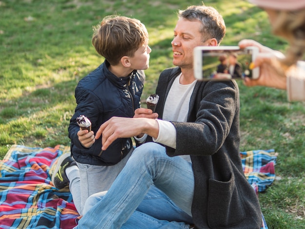 Free photo mother taking a picture of father and son