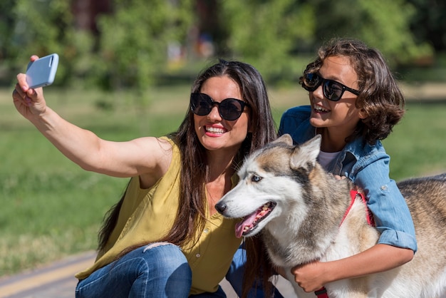 Mother taking selfie of son and dog at the park