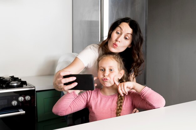 Mother taking selfie with daughter