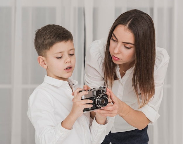 Mother teaches young boy to use camera