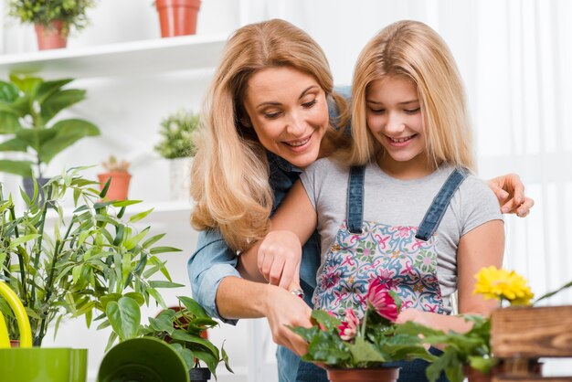 Mother teaching girl to plant flowers