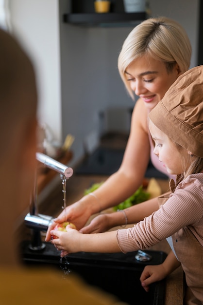 家で子供たちに料理を教える母親