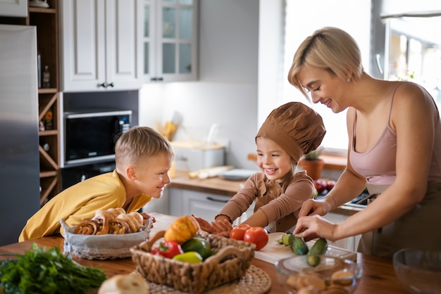 Free photo mother teaching her children to cook at home