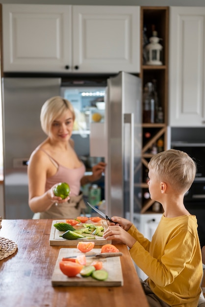 Free photo mother teaching her children to cook at home