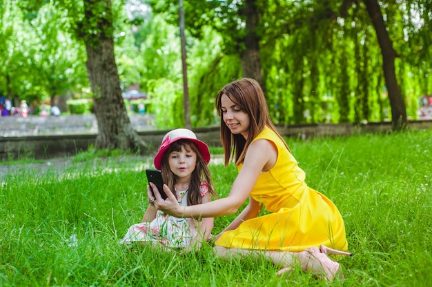 Mother teaching her daughter her phone