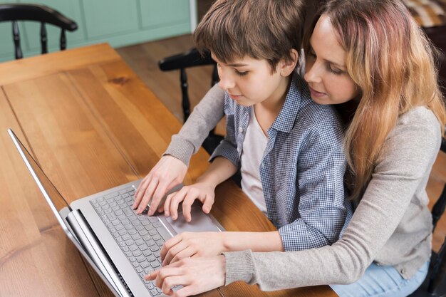 Мать учит сына пользоваться ноутбуком