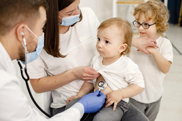 Mother and two her sons have an appointment with pediatrician