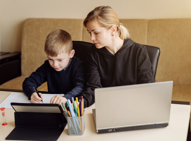 ノートパソコンとタブレットの指導を使用して、自宅の息子と自宅の部屋でオンラインで母親