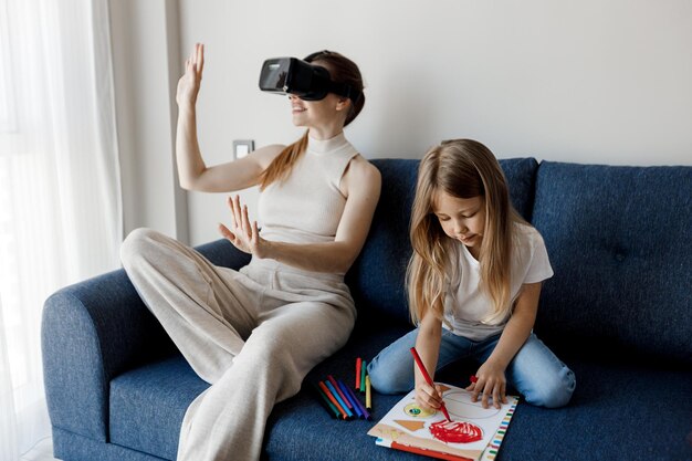 mother in VR glasses while her daughter playing and studiing