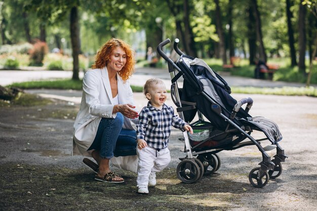 Мать гуляет в парке со своим маленьким сыном