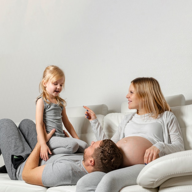 Mother watching father playing with cute little girl