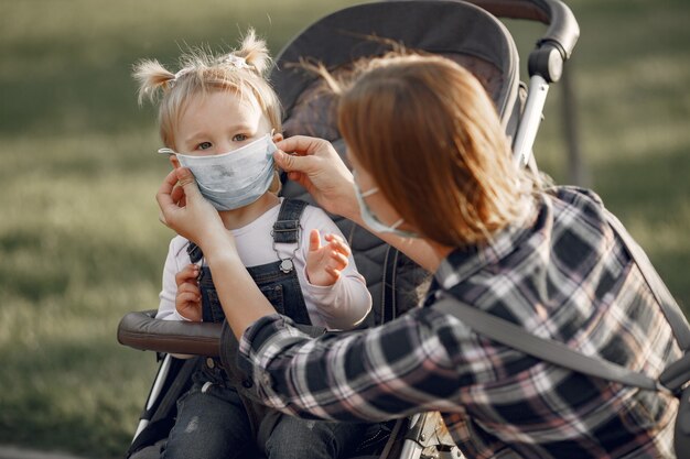Mother wearing face mask. Mom with baby pram during pandemic taking a walk outdoors.