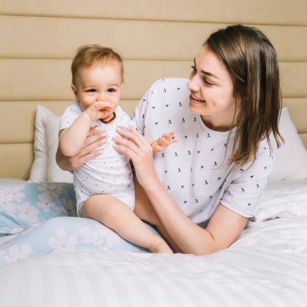 Free photo mother with baby in bed