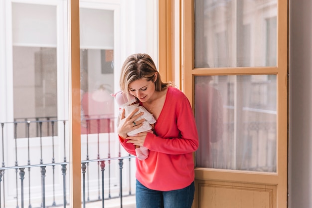 Mother with baby in front of window