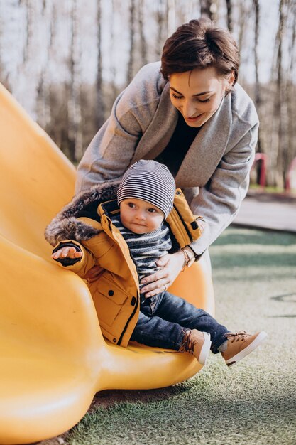 Mother with baby son having fun on playground