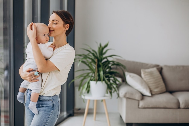 Foto gratuita madre con figlio bambino in piedi a casa vicino alla finestra