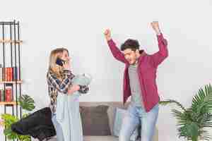 Free photo mother with baby talking on phone near cheerful father