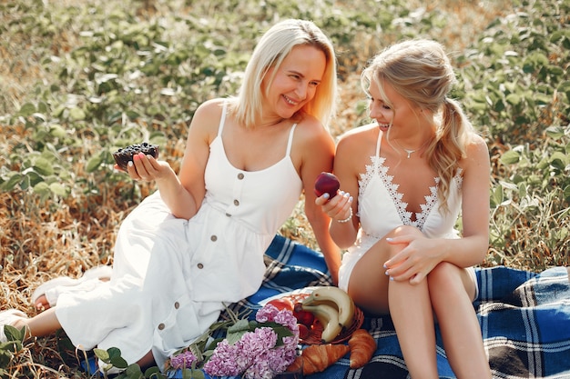 Mother with beautiful daughter in a autumn field