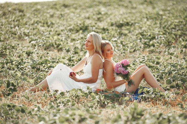 Mother with beautiful daughter in a autumn field