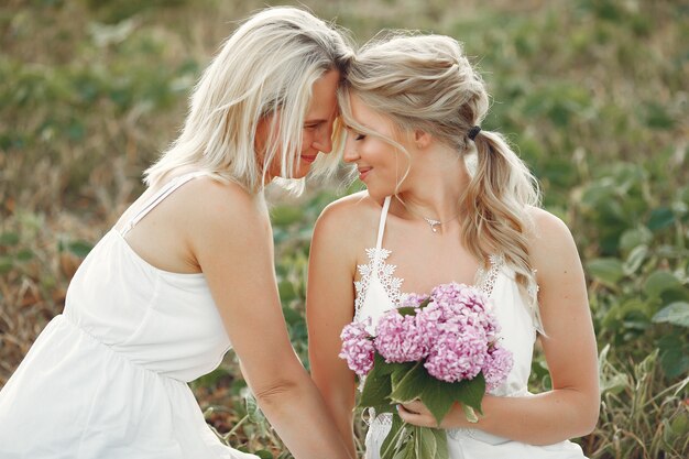 Mother with beautiful daughter in a autumn field