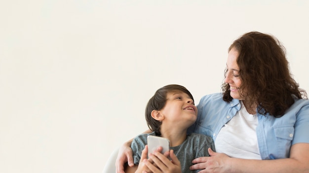 Foto gratuita madre con bambino alla ricerca di smartphone