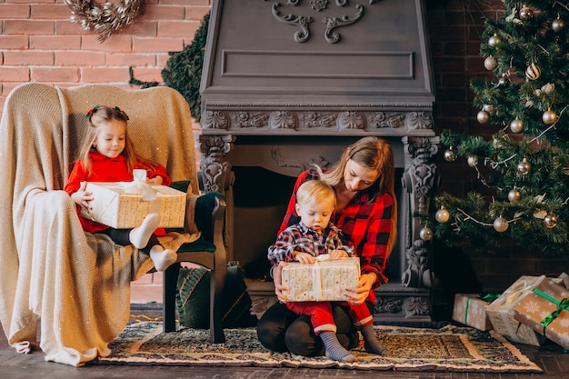 Mother with children by Christmas tree