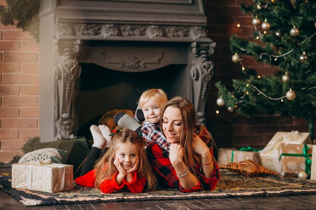 Mother with children by Christmas tree