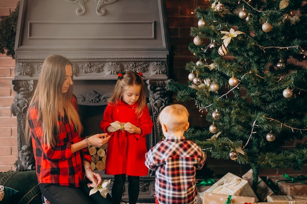 Mother with children by Christmas tree