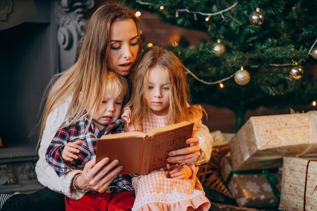 Mother with children by Christmas tree