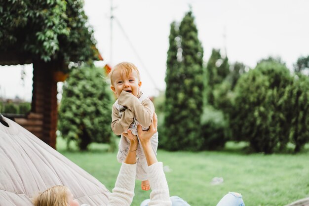 ハンモックで楽しんでいる子供を持つ母。ママと子供たちがハンモックで。