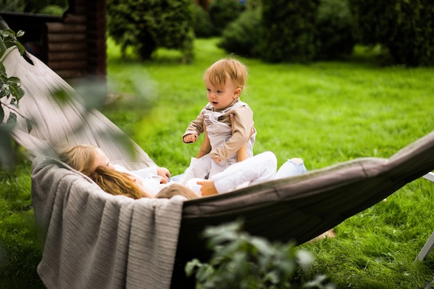 mother with children having fun in a hammock. Mom and kids in a hammock. 