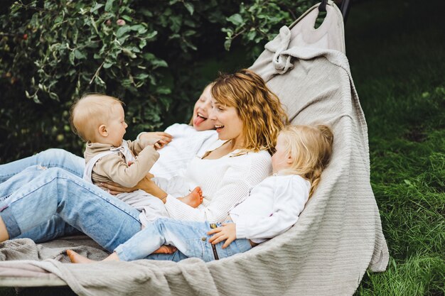 mother with children having fun in a hammock. Mom and kids in a hammock. 
