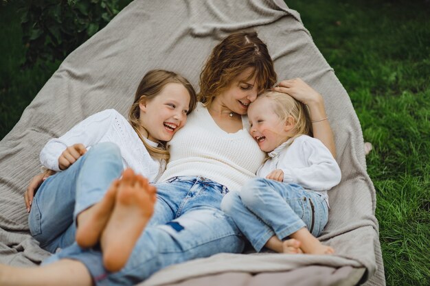 mother with children having fun in a hammock. Mom and kids in a hammock. 