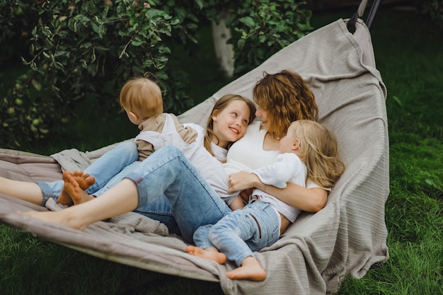 mother with children having fun in a hammock. Mom and kids in a hammock. 