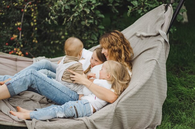 ハンモックで楽しんでいる子供を持つ母。ママと子供たちがハンモックで。