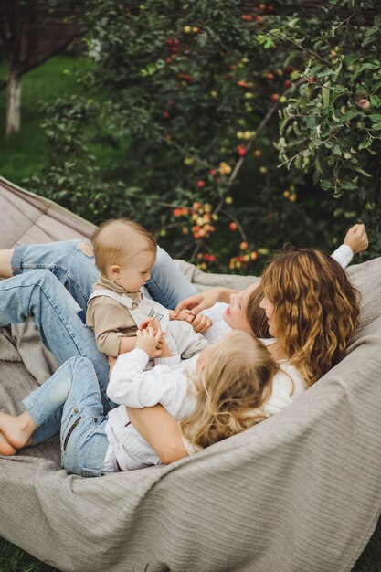 ハンモックで楽しんでいる子供を持つ母。ママと子供たちがハンモックで。