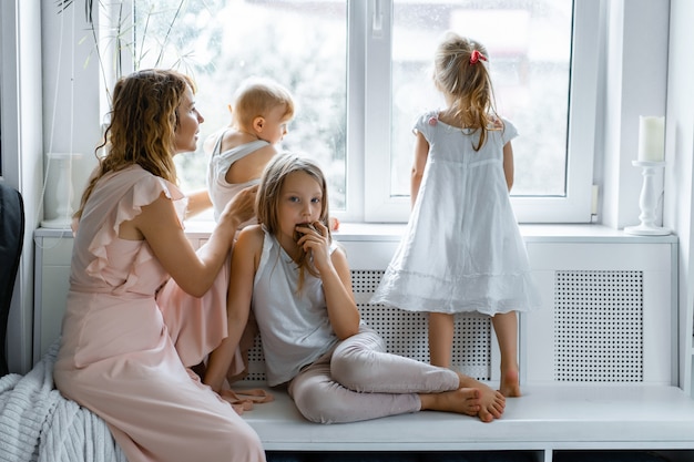 mother with children in a homely atmosphere. children by the window