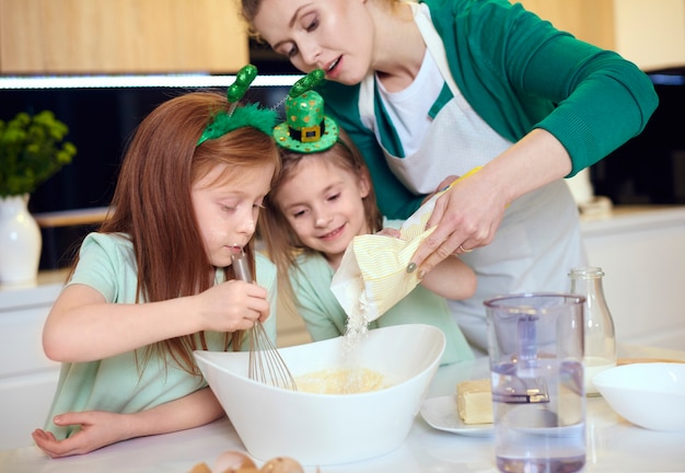 Мать с детьми, делающими печенье