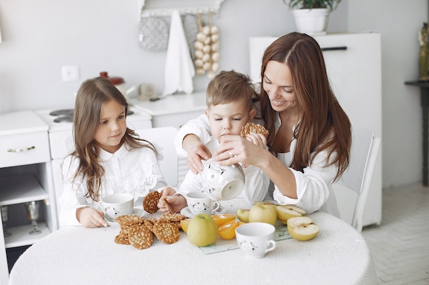 Mother with children sitting in a kitchen and have a meal