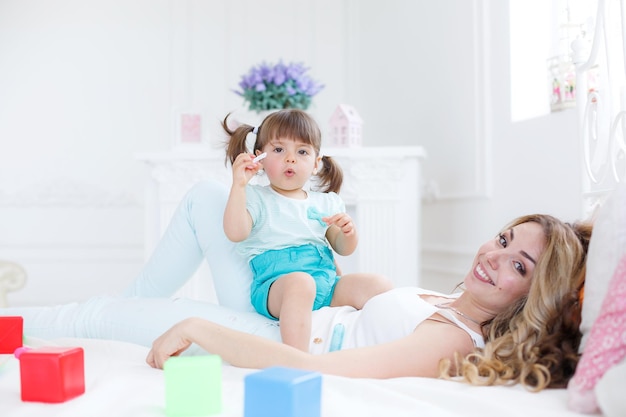 mother with cute baby playing at home