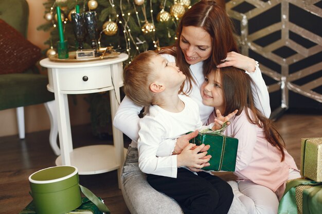 クリスマスツリーの近くのかわいい子供を持つ母