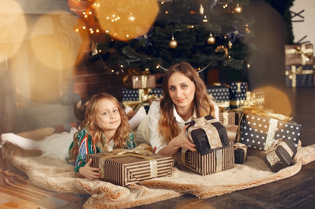 Mother with cute daughter at home near fireplace