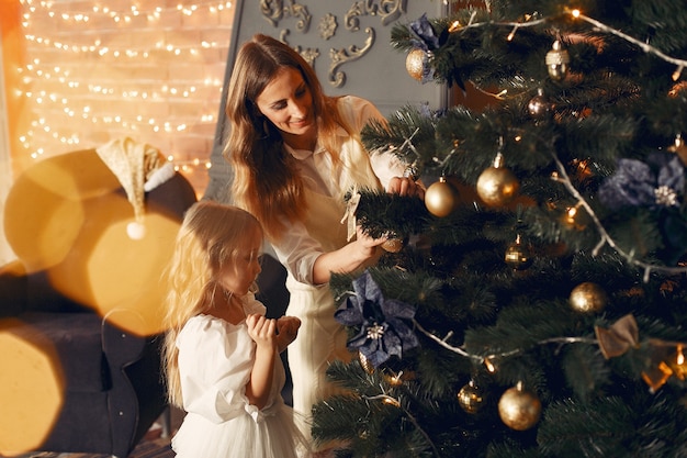 Mother with cute daughter at home near fireplace