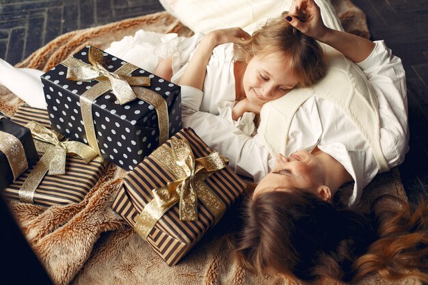 Mother with cute daughter at home near fireplace