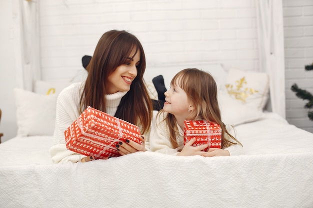 Mother with cute daughter at home with christmas gifts