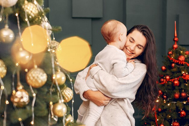 Mother with cute daughter near christmas tree