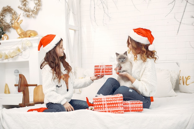 Mother with cute daughter sitting on a bed